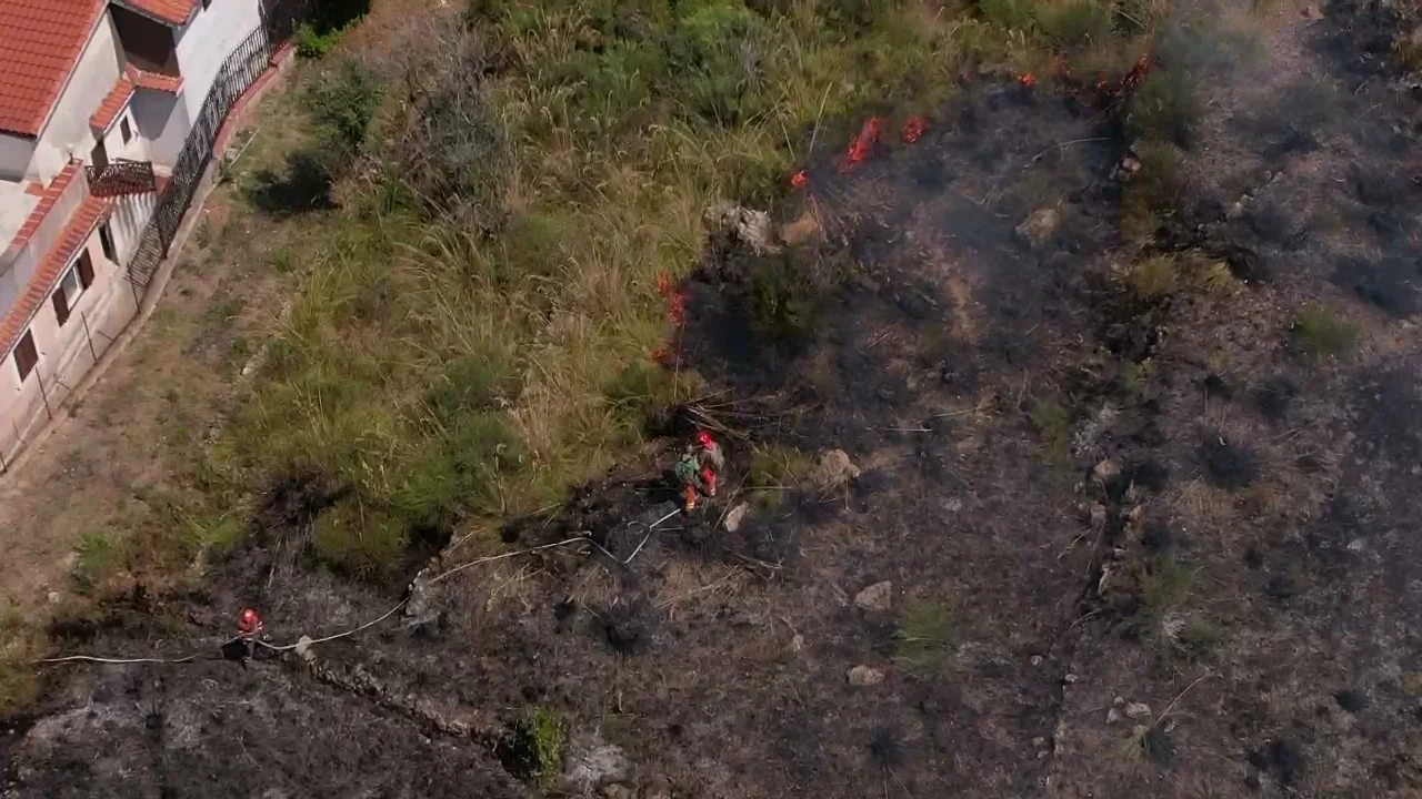 Squadre al lavoro su un fronte di incendio, riprese dal drone